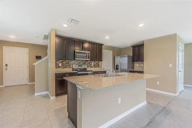a view of kitchen with refrigerator stove microwave and cabinets
