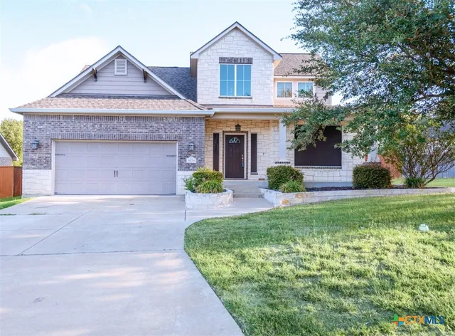 a front view of a house with a garden and plants