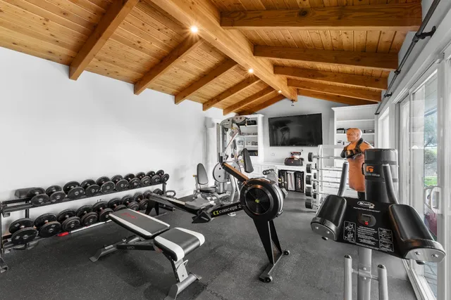 a view of house in front of a big yard with large trees
