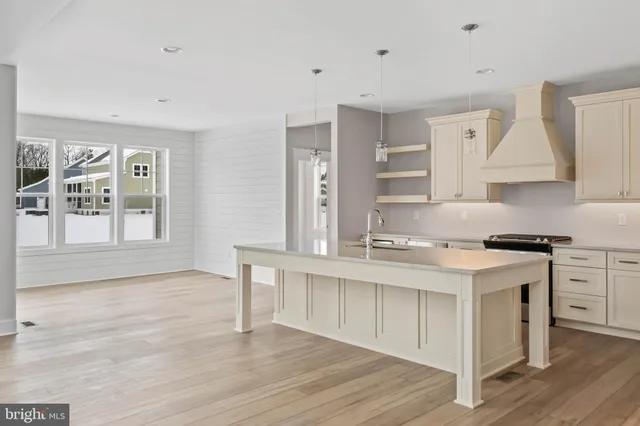 a kitchen with stainless steel appliances granite countertop a stove a sink dishwasher and a refrigerator with wooden floor