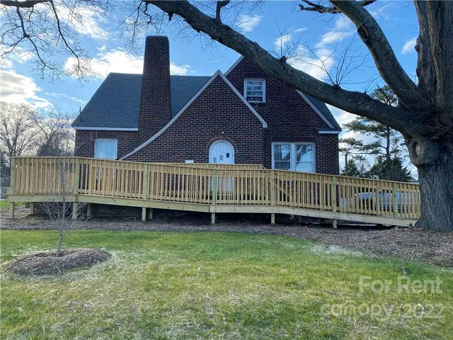 a view of a house with a yard and deck