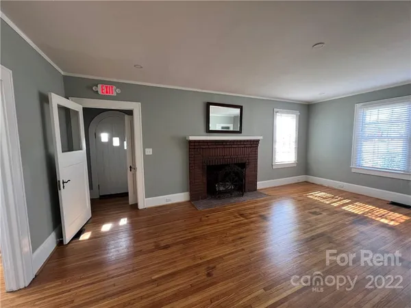 an entryway and livingroom with fireplace wooden floor and window