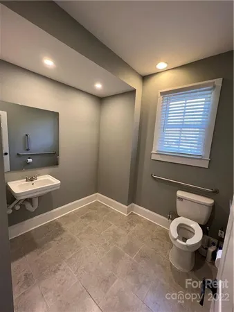 a bathroom with a sink mirror vanity and toilet