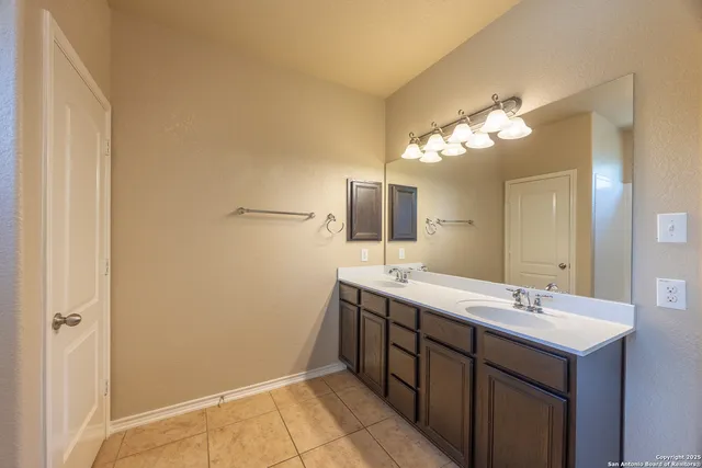 a bathroom with a double vanity sink and a mirror