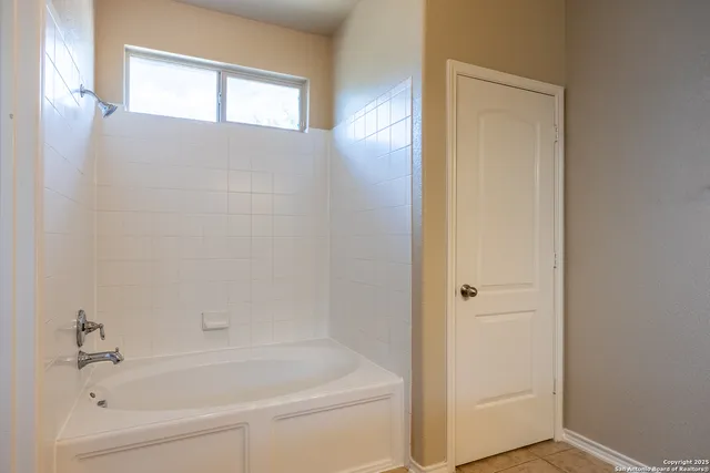 a white bath tub sitting next to a white cabinet