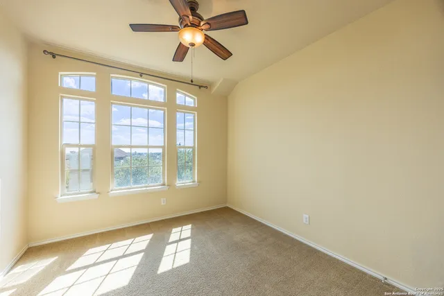 an empty room with a window and a fan