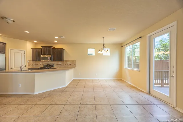 a view of kitchen with granite countertop window and refrigerator