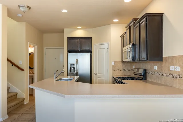 a kitchen with stainless steel appliances granite countertop a sink refrigerator and microwave