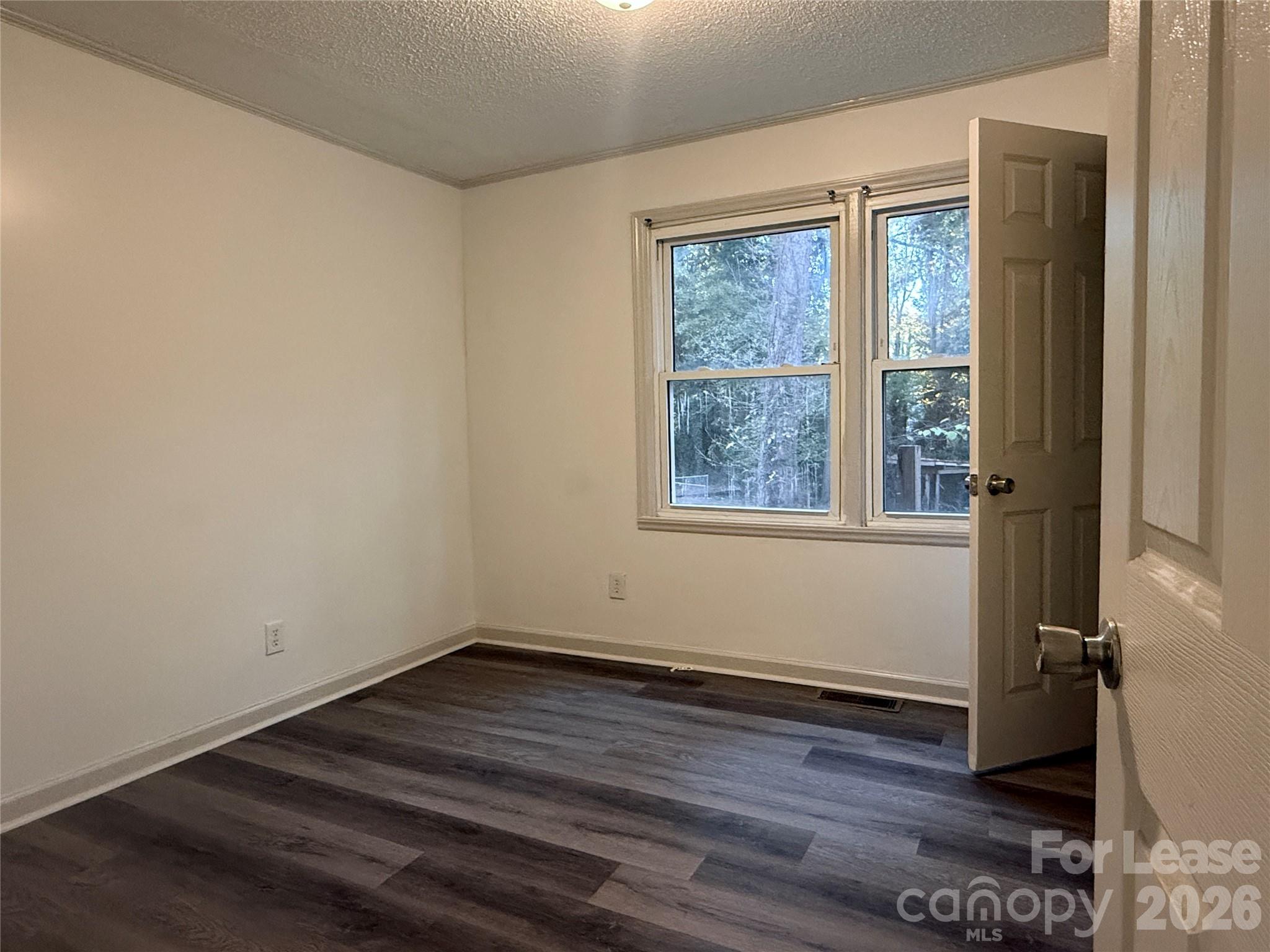 9225 Moores Chapel Road Charlotte, NC 28214 - Photo 12 of 19 an empty room with wooden floor and windows