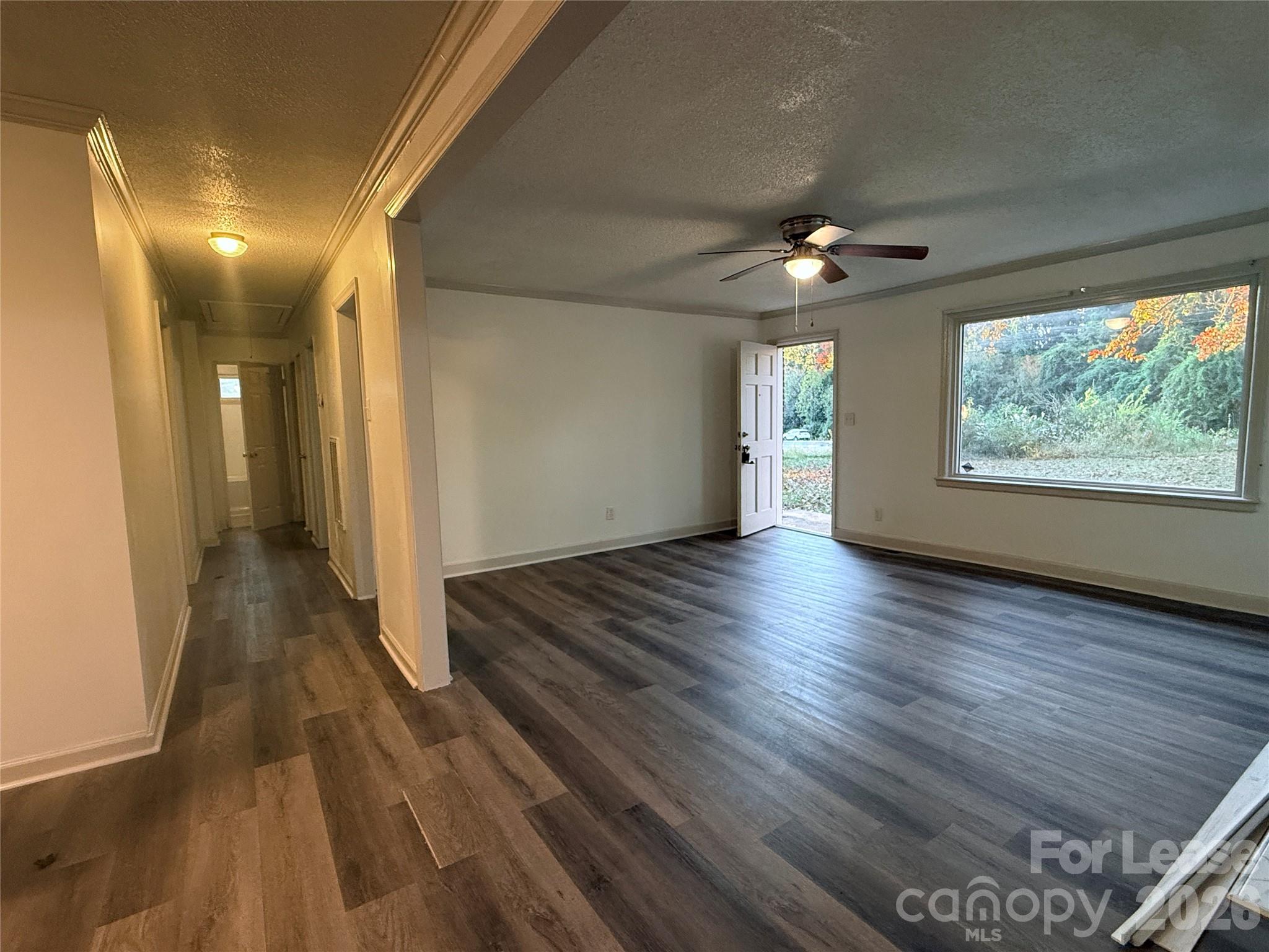 9225 Moores Chapel Road Charlotte, NC 28214 - Photo 5 of 19 a view of a room with wooden floor ceiling fan and windows