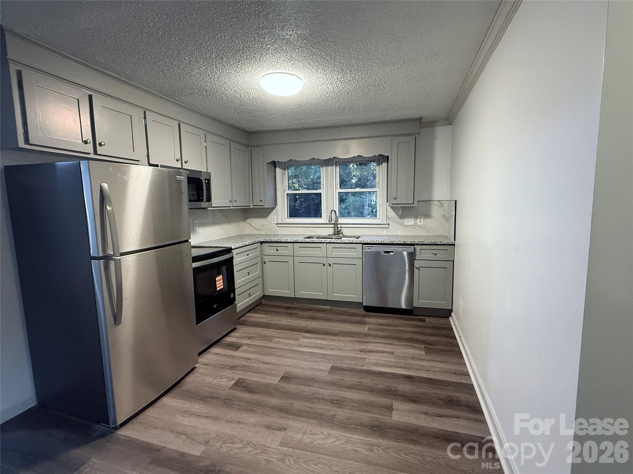 9225 Moores Chapel Road Charlotte, NC 28214 - Photo 7 of 19 a kitchen with stainless steel appliances granite countertop a refrigerator a sink a stove top oven a refrigerator and a window