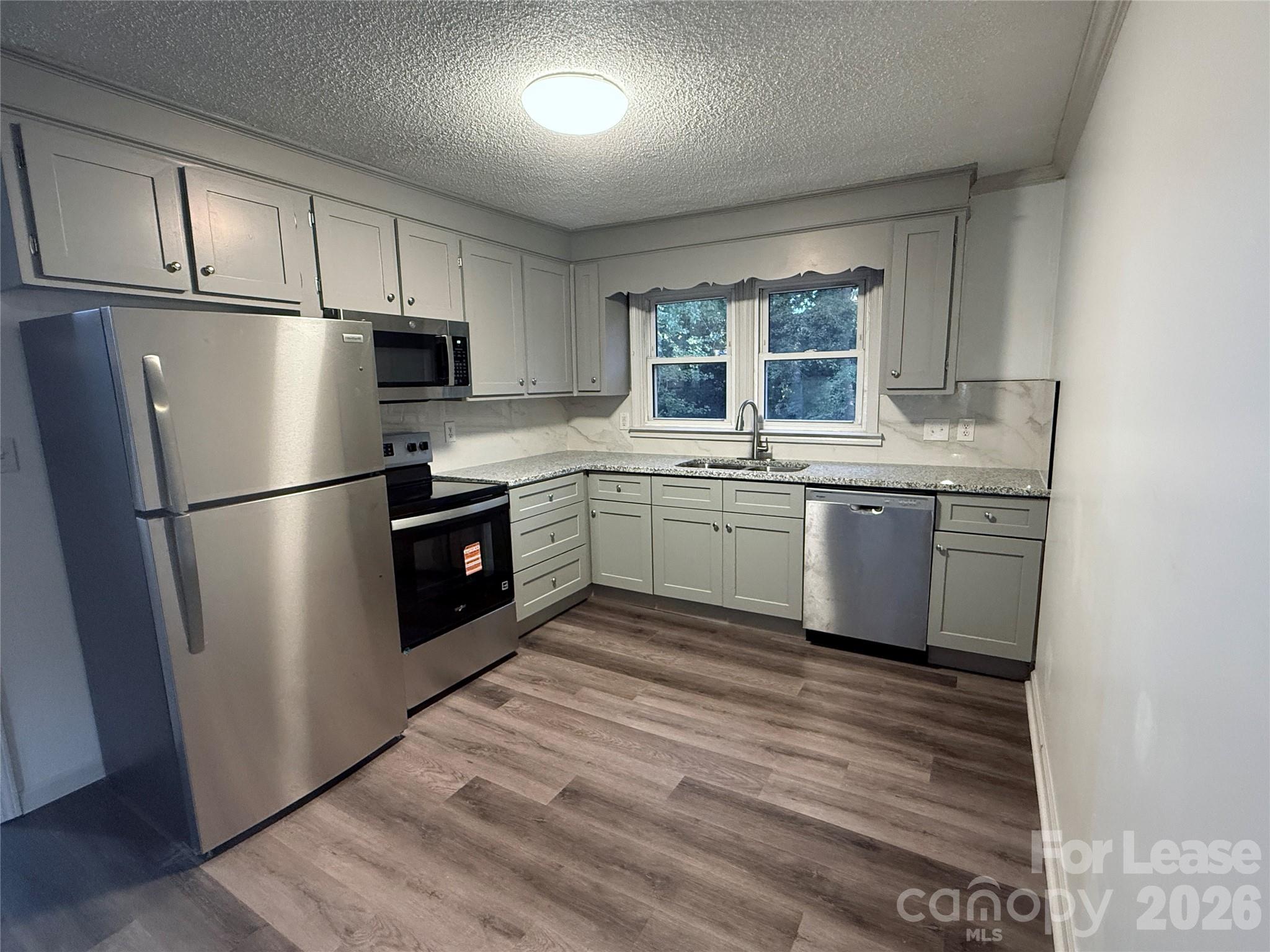 9225 Moores Chapel Road Charlotte, NC 28214 - Photo 8 of 19 a kitchen with stainless steel appliances granite countertop a refrigerator a sink a stove a refrigerator and white cabinets