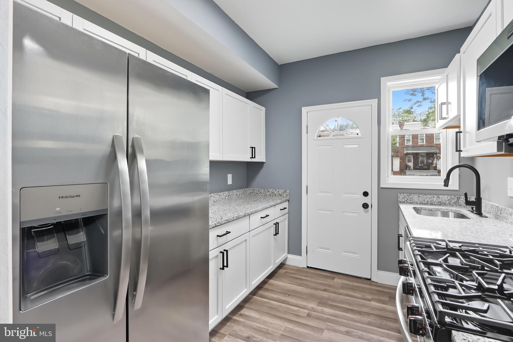 1309 East Patapsco Avenue Baltimore, MD 21225 - Photo 13 of 34 a kitchen with stainless steel appliances granite countertop a refrigerator a sink and white cabinets