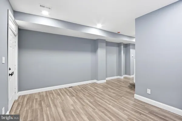 a view of empty room with wooden floor