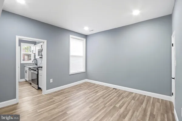 a view of empty room with wooden floor