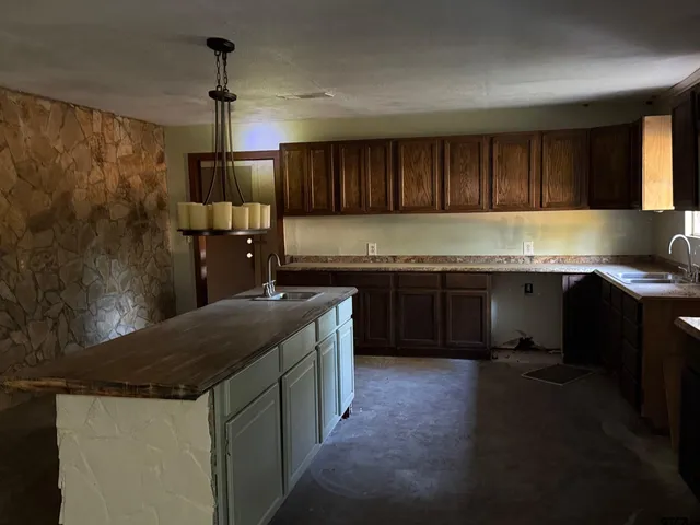 a kitchen with a sink a counter top space cabinets and stainless steel appliances