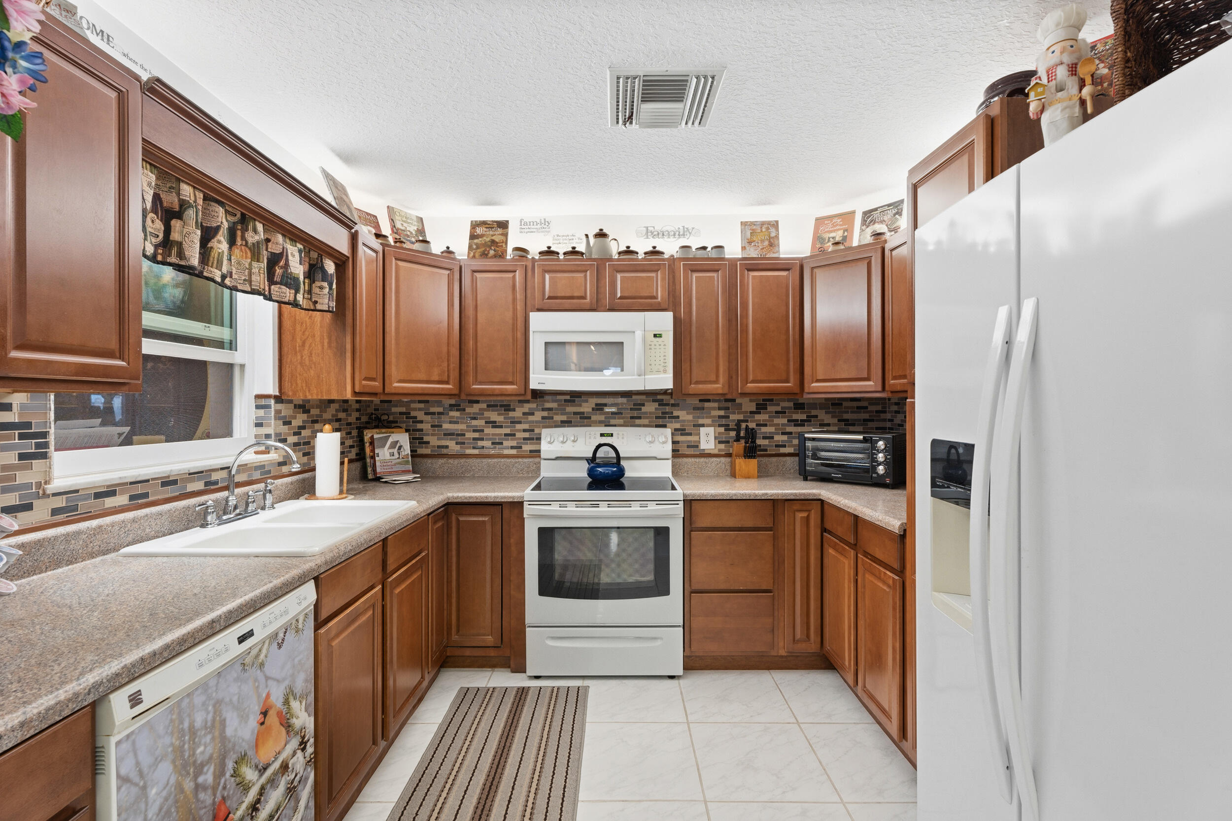 1341 Southeast Seashell Lane Stuart, FL 34996 - Photo 6 of 24 a kitchen with stainless steel appliances a sink stove cabinets and refrigerator