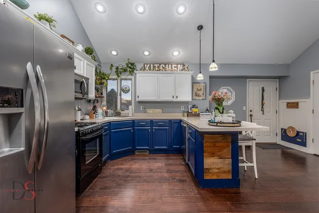 a kitchen with stainless steel appliances granite countertop a sink a stove and a refrigerator