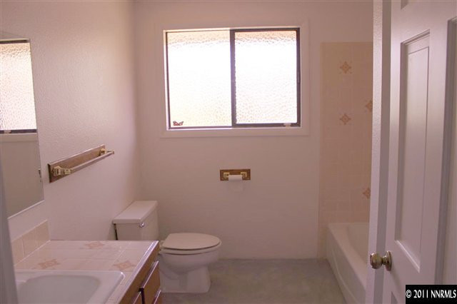 4215 Lakeside Drive Reno, NV 89509 - Photo 11 of 13 a white toilet sitting next to a window in a bathroom
