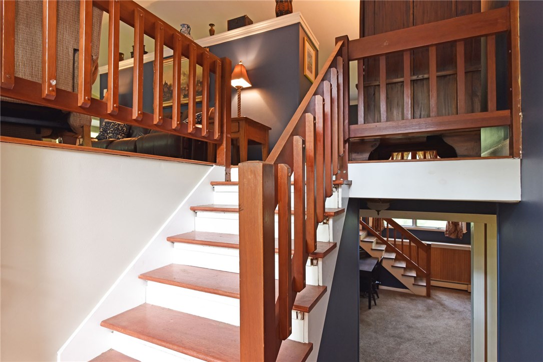 33 Ramble Road Glocester, RI 02857 - Photo 5 of 22 Cool, modern feel to the interior layout with view of front staircase, as well as back staircase to lower level family room with great natural light and a wood burning stove.