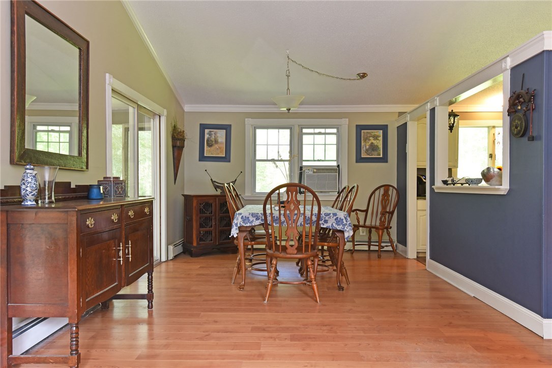 33 Ramble Road Glocester, RI 02857 - Photo 8 of 22 Dining area with kitchen off to the right and screened in porch with two sets of sliders along the whole wall to the left.