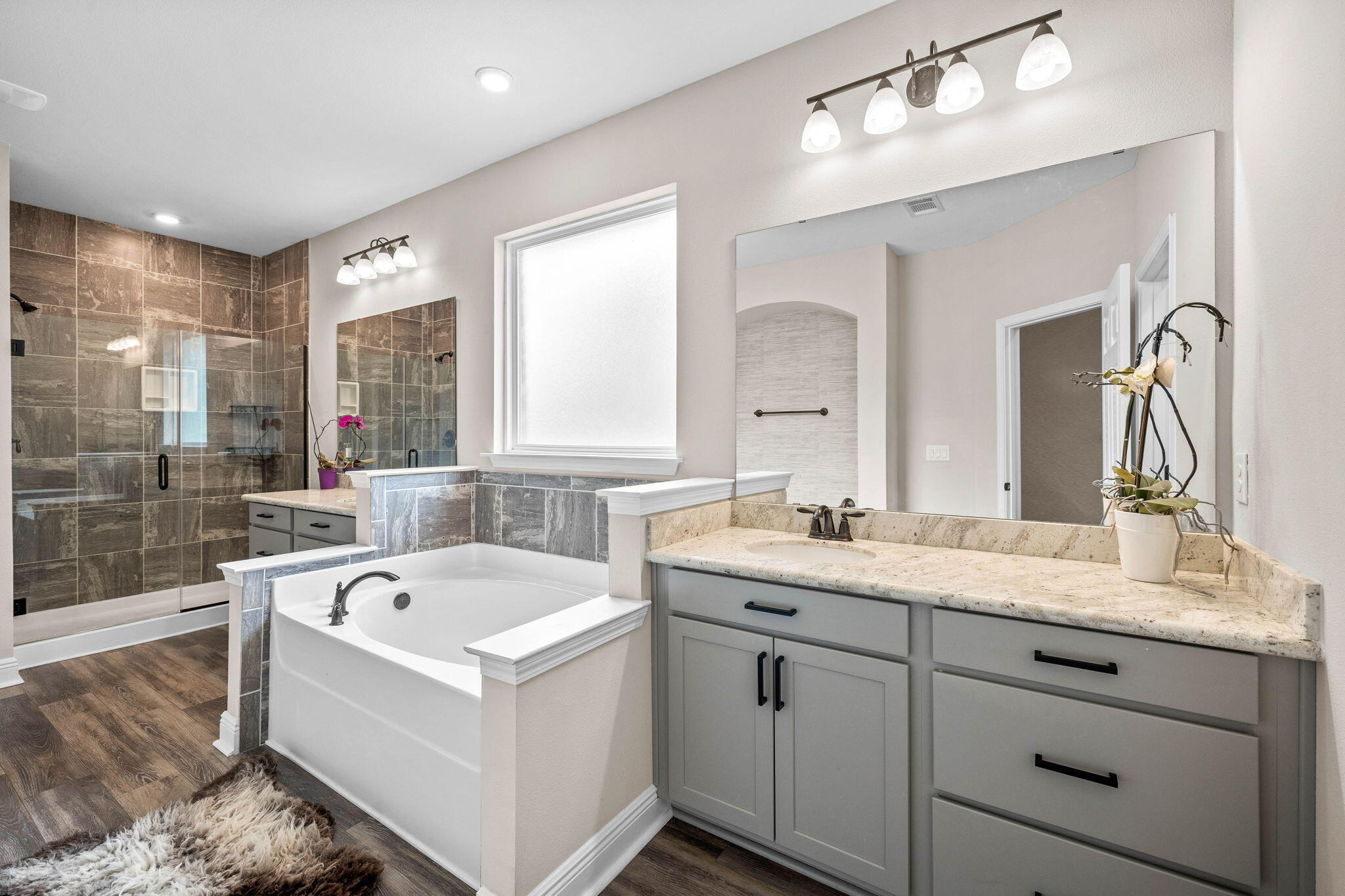 1297 Brushed Dune Circle Freeport, FL 32439 - Photo 32 of 73 a bathroom with a tub a sink double vanity and a mirror