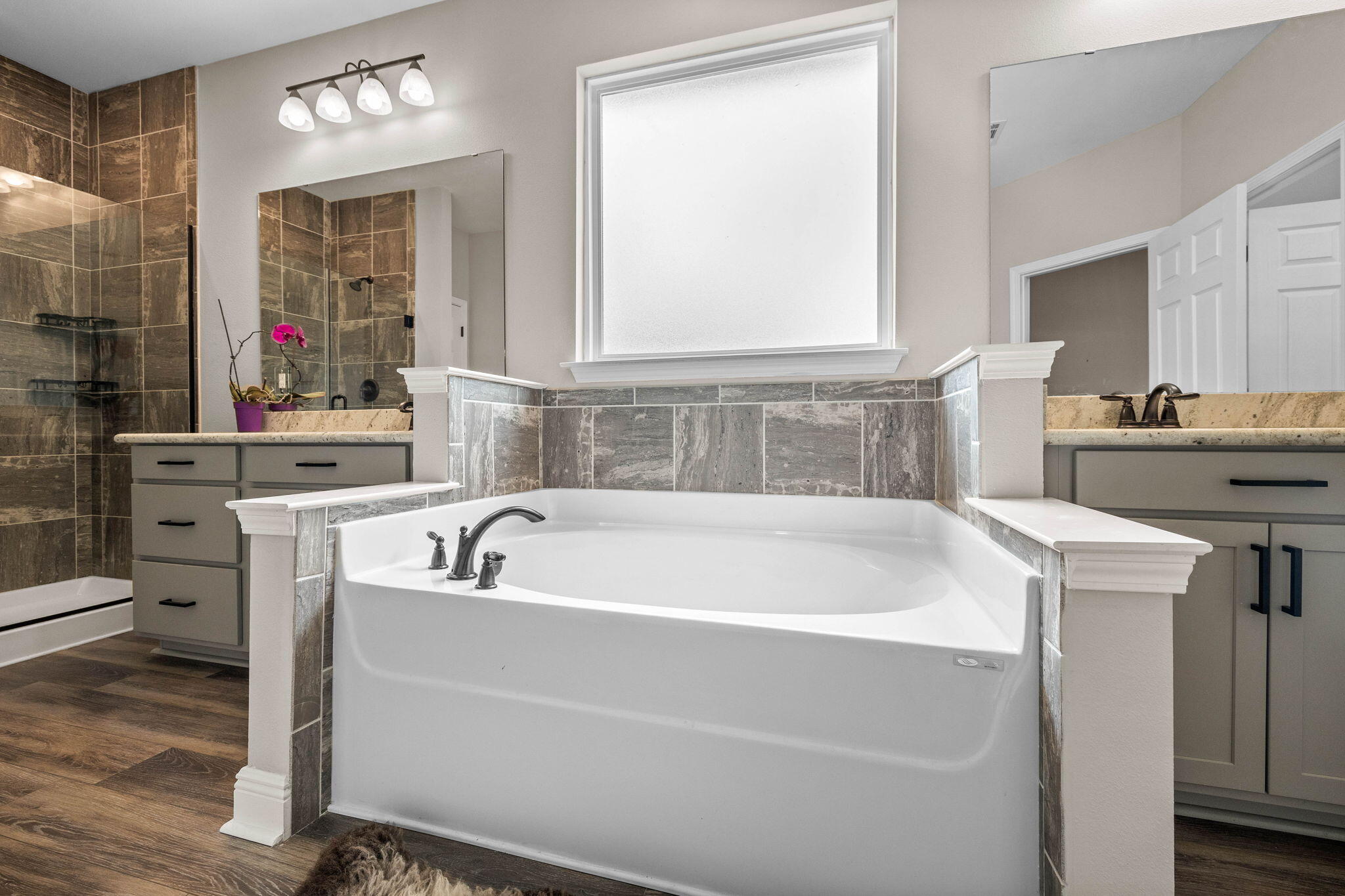 1297 Brushed Dune Circle Freeport, FL 32439 - Photo 35 of 73 a bathroom with a bathtub a mirror a sink and a window