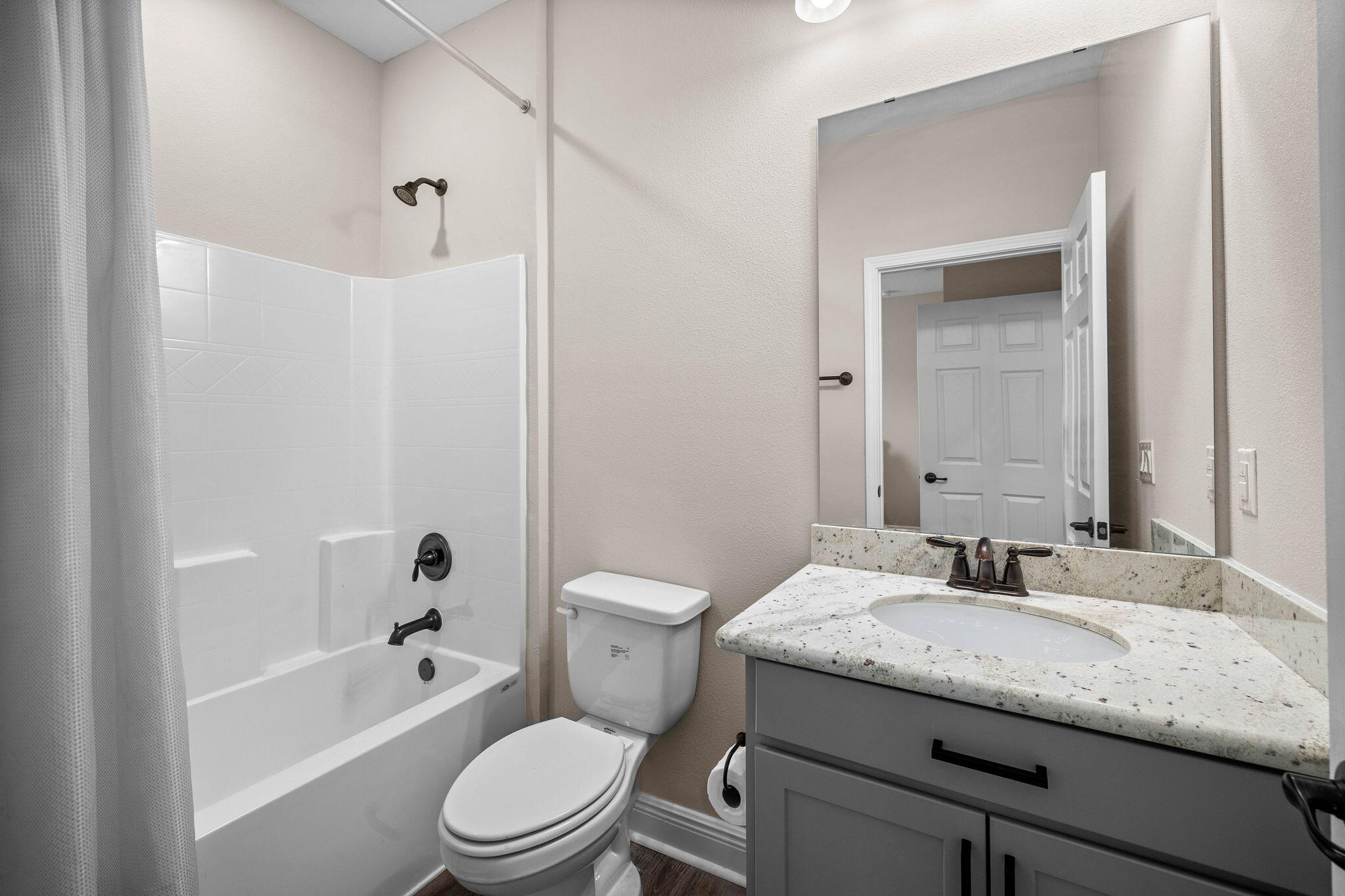 1297 Brushed Dune Circle Freeport, FL 32439 - Photo 49 of 73 a bathroom with a granite countertop toilet a sink and a bathtub