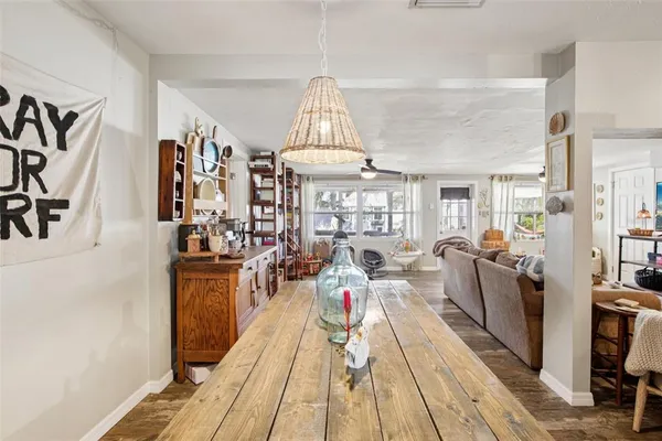a view of a dining room with furniture a chandelier and wooden floor