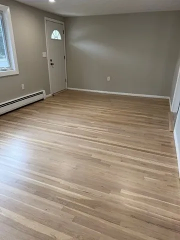 a view of an empty room with wooden floor