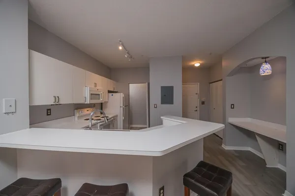 a kitchen with stainless steel appliances a refrigerator sink and white cabinets