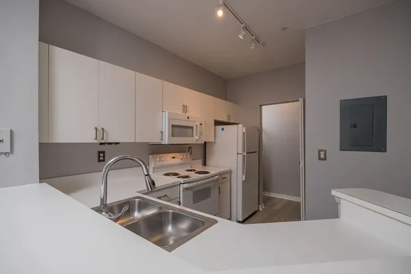 a view of a refrigerator in kitchen and white cabinets