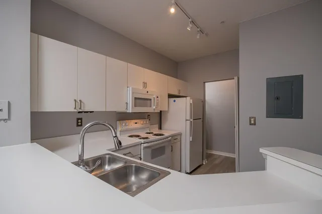 a view of a refrigerator in kitchen and white cabinets