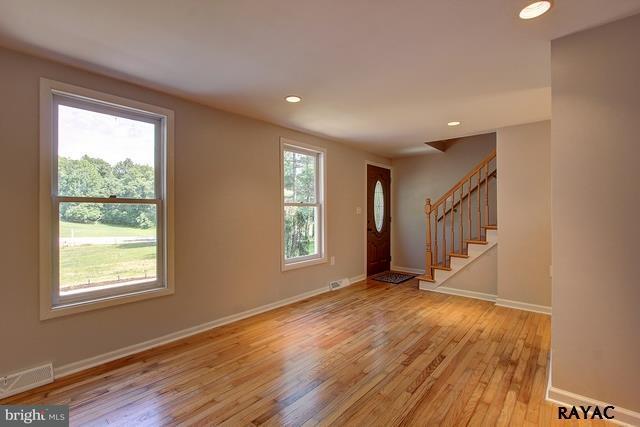 7952 Hickory Road Stewartstown, PA 17363 - Photo 4 of 14 a view of an empty room with wooden floor and a window