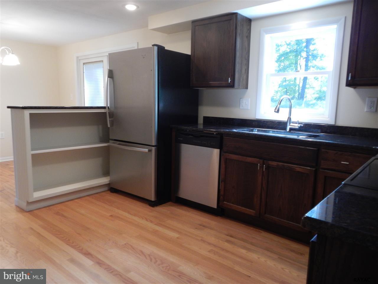 7952 Hickory Road Stewartstown, PA 17363 - Photo 5 of 14 a kitchen with granite countertop stainless steel appliances a refrigerator cabinets and a window