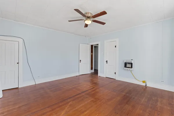 an empty room with closet and a ceiling fan