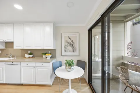 a view of a kitchen area with furniture and wooden floor
