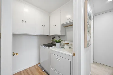 a utility room with cabinets washer and dryer