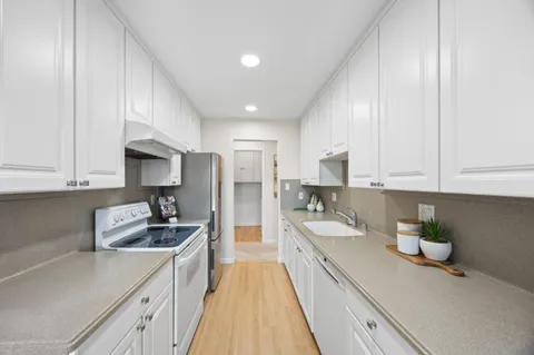 a kitchen with granite countertop a sink stainless steel appliances and cabinets