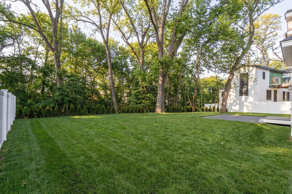 74 Gary Road Needham, MA 02494 - Photo 3 of 41 a view of a grassy field with trees in the background
