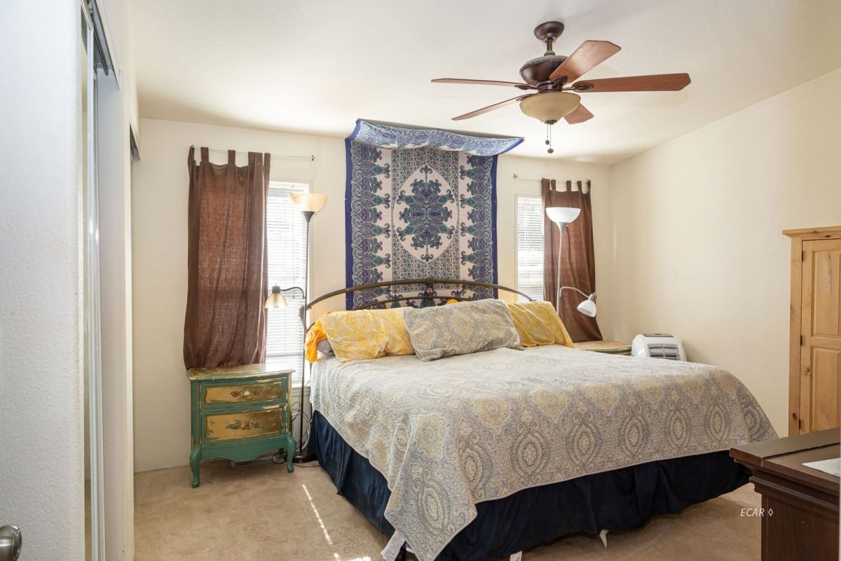 426 Spring Valley Parkway Spring Creek, NV 89815 - Photo 10 of 16 a bedroom with a bed and a chandelier