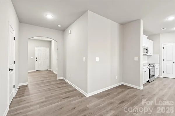 a view of a hallway with wooden floor and closet