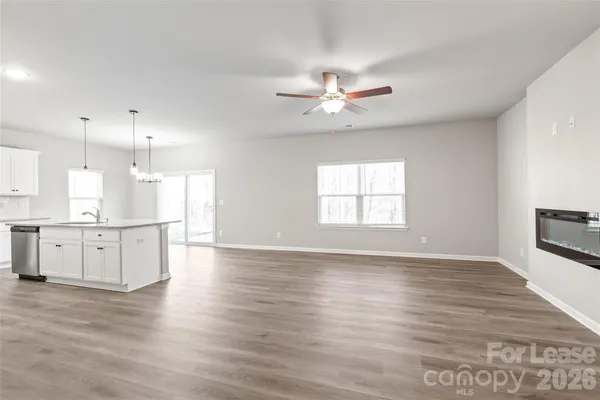 a view of an empty room with kitchen appliances and a window