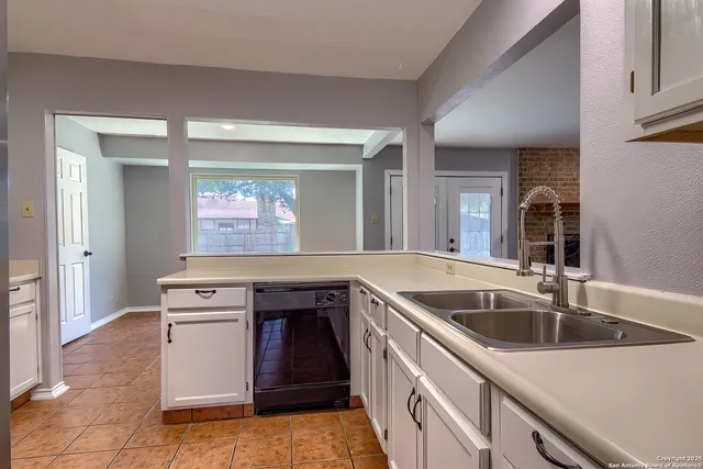 a kitchen with a stove sink and cabinets