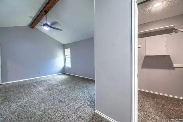 an empty room with windows and fan