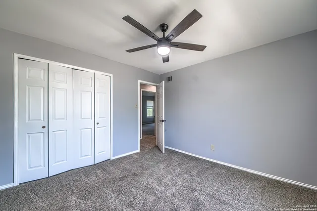 an empty room with closet and windows