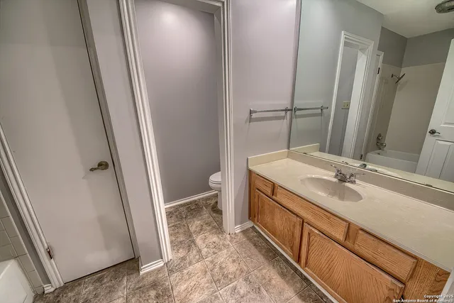 a bathroom with a sink a toilet and a mirror