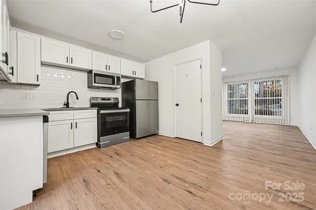 a kitchen with stainless steel appliances a refrigerator sink and cabinets