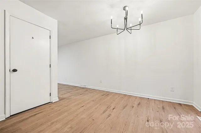 a view of a room with wooden floor and white walls