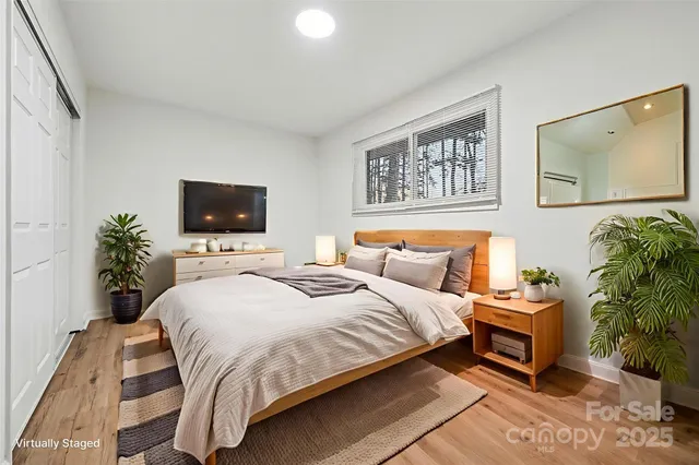 a bedroom with a bed and a flat screen tv